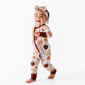 Toddler wearing Kiki + Lulu - Everything I Dough, I Dough It For You Cookies Convertible Footies with playful cookie and milk pattern, soft fabric, and matching headband, perfect for stylish kids.