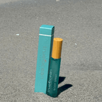 True Ocean - True Ocean Body Spray - Pocket Size in teal with wooden cap standing on textured gray surface, showcasing compact and stylish scent option for on-the-go use.
