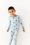 Child wearing a blue checkered pajama set with cartoon characters on a white background