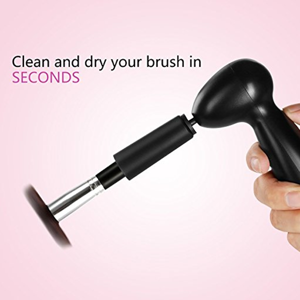 Hand holding the AN Commerce - Makeup Brush Cleaner and Dryer Bowl in black, demonstrating fast cleaning and drying of a makeup brush against a soft pink background.