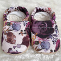 Soft baby shoes with a floral pattern in purple and pink tones, designed for comfort and style, featuring the product title CLAMFEET - ELIZABETH from a curated children’s boutique.
