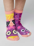Child wearing Pals Socks - Owl & Mouse Mismatched Animals Non-Slip Socks for Kids in bright purple, pink, yellow, and peach colors with playful animal designs and soft cozy fabric.