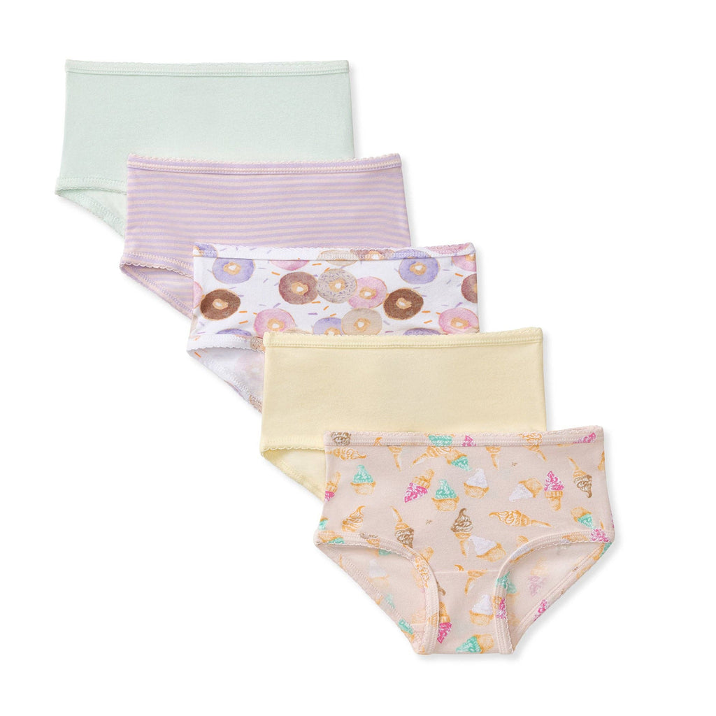 Four pairs of girl's brief underwear arranged in a staggered stack on a white background. The top pair is light mint green, the second has thin pink stripes, the third has a donut print on a white background, the fourth is pale yellow, and the bottom pair has a pastel multicolor ice cream cone print on a peach background.