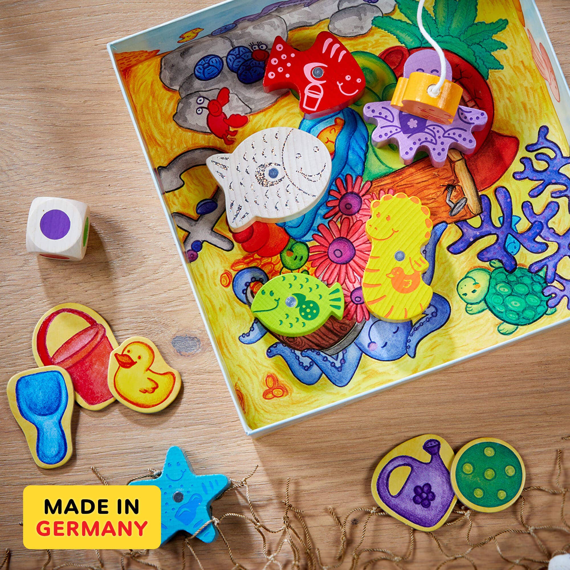 Colorful magnetic fishing game pieces including fish, sea creatures, and playful items arranged on a vibrant underwater-themed board, showcasing My Very First Games - Here, Fishy, Fishy! Magnetic Game from a curated children’s boutique focused on stylish essentials for little ones and moms.
