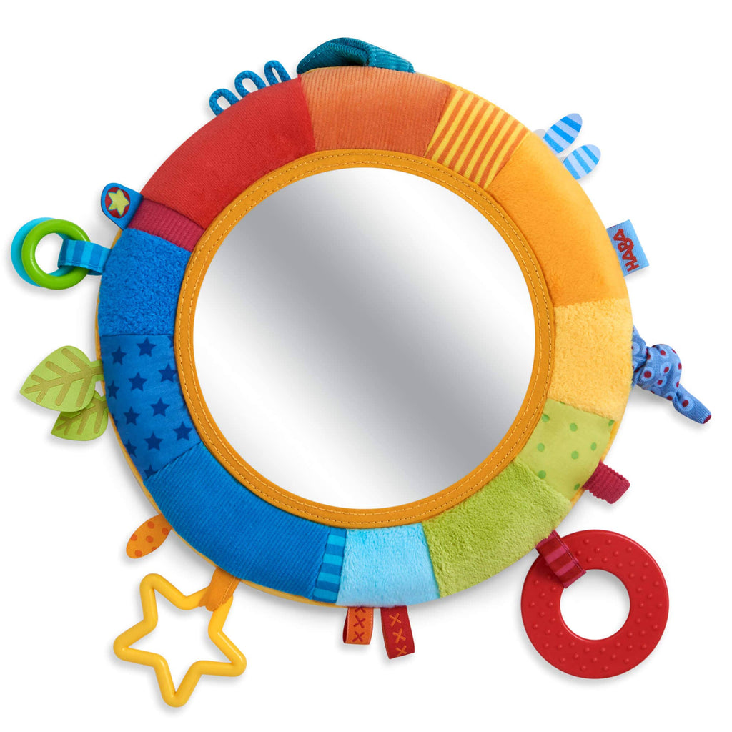 Rainbow Discovery Mirror with a soft, colorful fabric frame featuring textured and tactile elements for sensory play, perfect for babies and toddlers in a stylish children’s boutique.