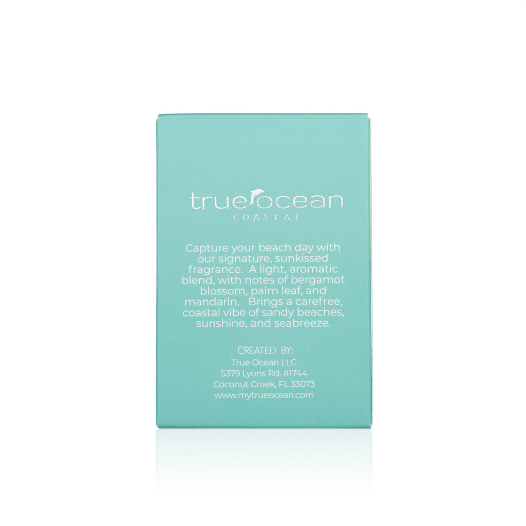 Back view of a turquoise box featuring a description of True Ocean - Coastal - a beach perfume, highlighting its light, aromatic blend with bergamot blossom, palm leaf, and mandarin notes.