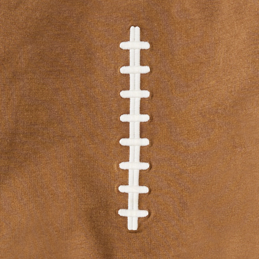 Close-up of a football sweatshirt with white laces on a brown background.