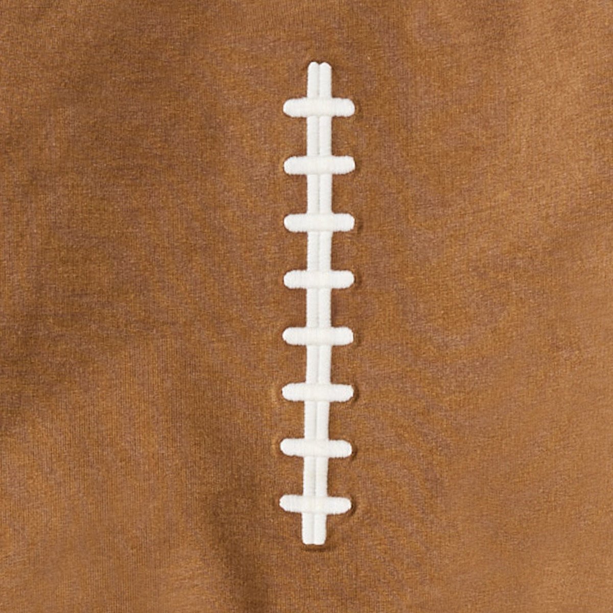 Close-up of a football sweatshirt with white laces on a brown background.