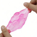 A translucent pink squishy toy being stretched between two hands against a plain white background.