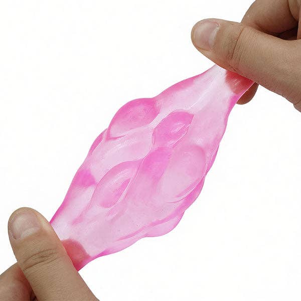 A translucent pink squishy toy being stretched between two hands against a plain white background.