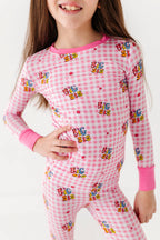 Child wearing pink checkered pajamas with 'Big Sis' text on a white background