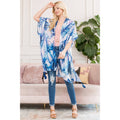 Woman wearing Love and Repeat - BOTANICAL LEAF PRINTED KIMONO: BLUE MULTI over casual outfit in a cozy living room, showcasing stylish essentials for little ones and moms.