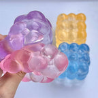 Colorful gummy bear-shaped soaps held by a hand against a light background
