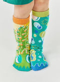 Child wearing colorful Pals Socks - Pokey & Poppy - Mismatched Cactus Bubble Non-Slip Kids Socks, perfect for cozy, stylish kids clothing in a curated children’s boutique.