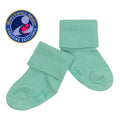 Pair of soft mint green baby socks with fold-over cuffs displayed alongside a Mom’s Choice Award seal, featuring babysoy Inc - Babysoy Modern Stay on Socks: Harbor.