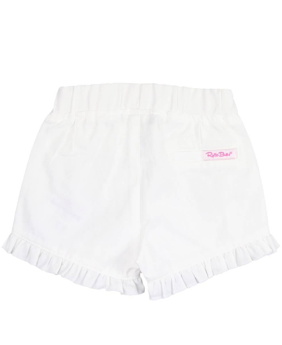 RuffleButts + RuggedButts - Toddler Girls White Ruffle Trim Woven Shorts: White soft white toddler shorts with ruffle trim edges and elastic waistband, perfect for stylish kids clothing in a curated children’s boutique.