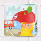 Magic Muddy Day Color Changing Bath Book with colorful illustrations of a child in a raincoat holding an umbrella, featuring a frog and playful bubbles, perfect for sensory play.