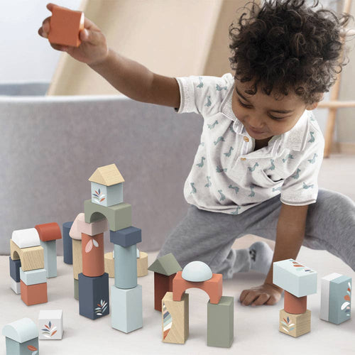 Child playing with colorful pastel wooden blocks arranged on a soft surface, promoting imaginative play and development with Speedy Monkey - Building Blocks (50 pieces) from a curated children’s boutique.