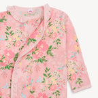 Pink floral baby romper with ruffled collar on a light pink background