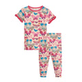 A two-piece children's pajama set featuring a short-sleeve top and matching leggings with an all-over colorful butterfly print on a light pink background.
