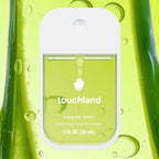 A 1 fl oz (30 mL) Touchland Power Mist hydrating hand sanitizer dispenser bottle, featuring a white cap and a translucent green body, set against a matching green liquid background with water droplets.