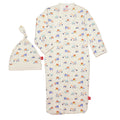 Baby sleep sack and matching bonnet set in cream with a colorful construction vehicle print, shown on a plain white background.