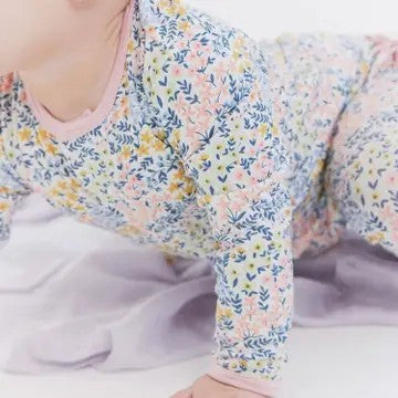 Baby wearing a floral patterned outfit on a white background