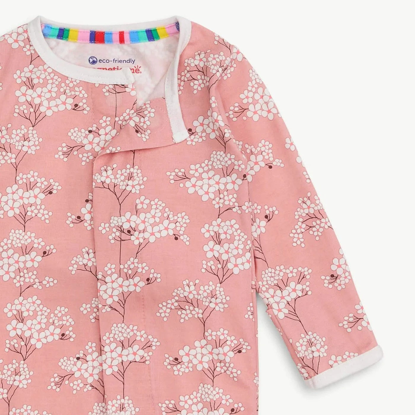 Pink floral patterned pajams with 'eco-friendly' label on a white background.
