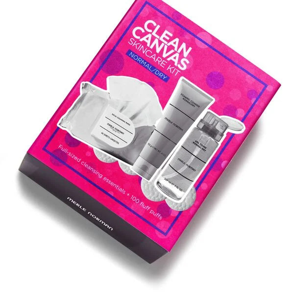 Bright pink box containing the Clean Canvas Skincare Kit (Limited-Edition) with clear bottles and containers designed for normal to dry skin, displayed with cleansing puffs.