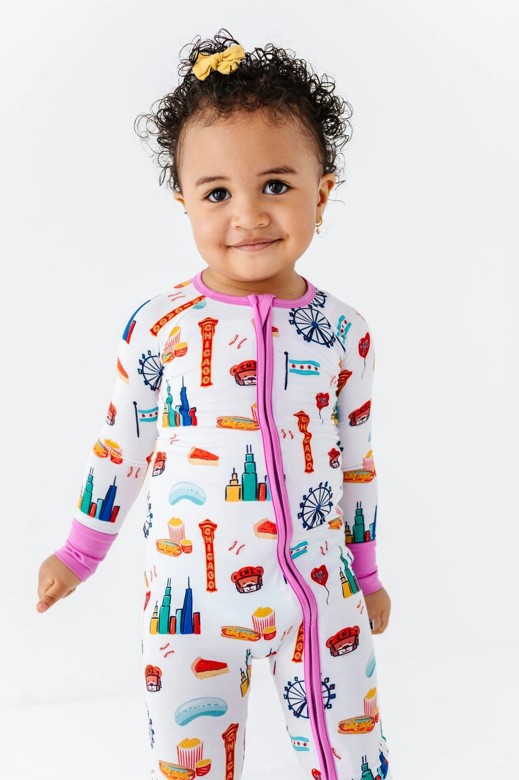 Toddler wearing Convertible Footies - Bamboo - Pink Chicago, featuring colorful Chicago-themed illustrations on a soft, breathable fabric designed for comfort and style.