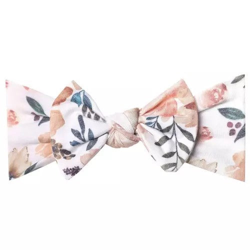 Peach, green, white floral newborn headband lying flat on white background.