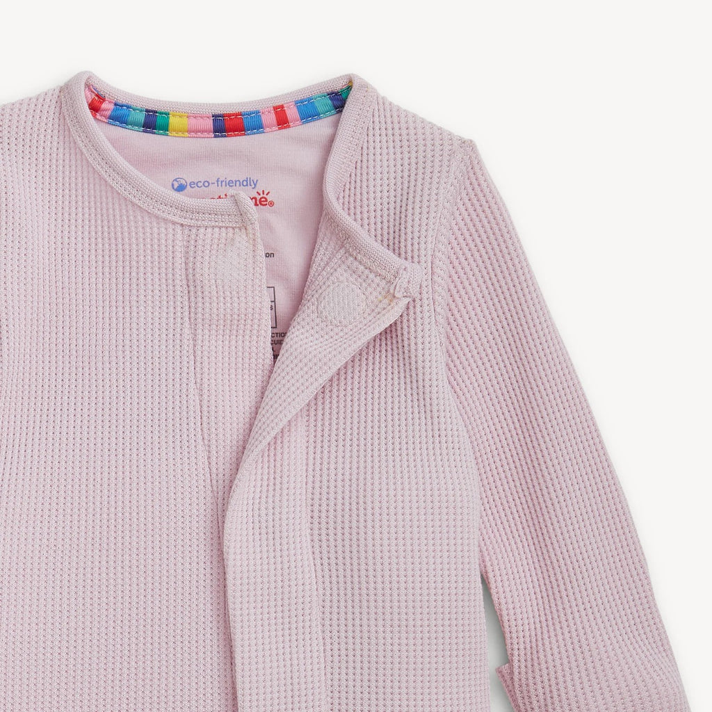 Pink waffle textured pajamas with a colorful trim on a white background.