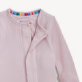 Pink waffle textured pajamas with a colorful trim on a white background.