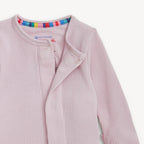 Pink waffle textured pajamas with a colorful trim on a white background.