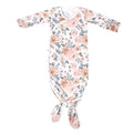 Peach, green and white floral pattern newborn knotted down lying flat on white background.