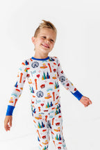 Child wearing Two-Piece Pajamas - Bamboo - Blue Chicago with colorful Chicago-themed illustrations on soft, breathable fabric designed for cozy bedtime comfort.