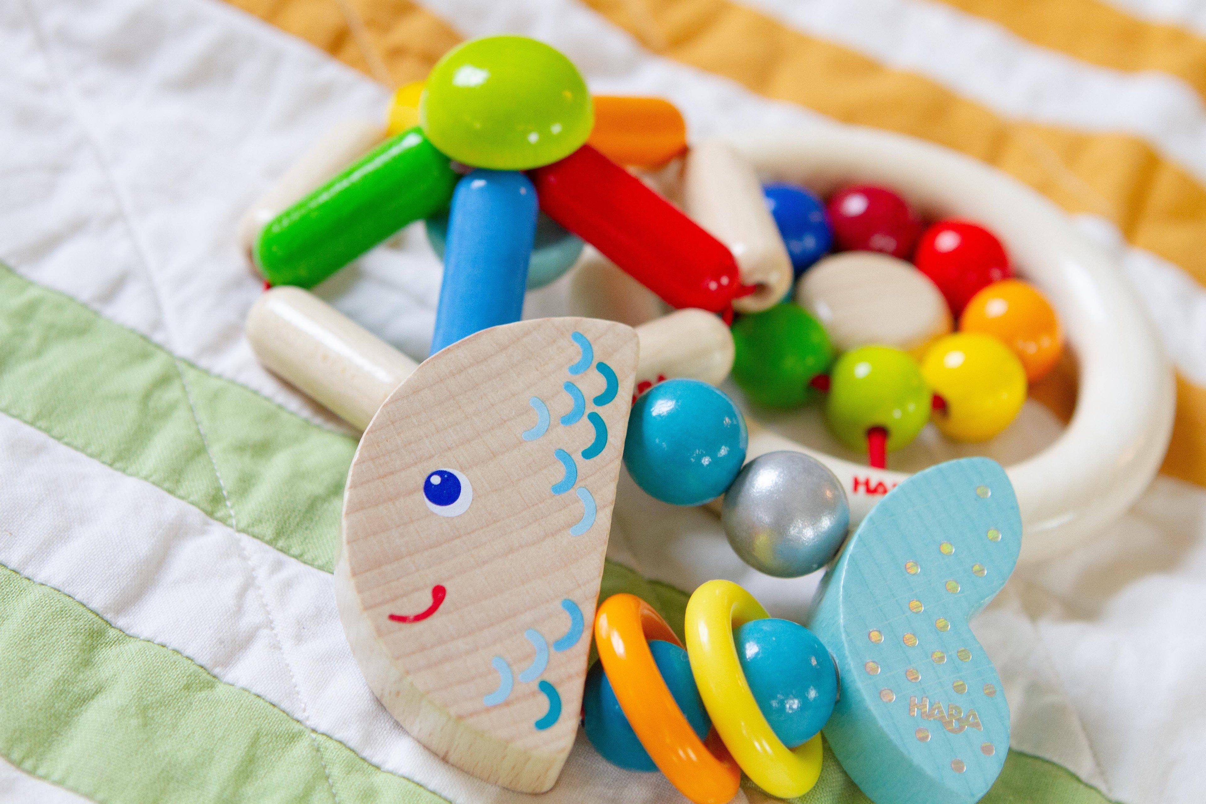 Rattlefish Wooden Baby Rattle featuring colorful beads and smooth wooden elements designed for sensory play and safe handling, perfect for modern baby essentials.