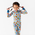 Child joyfully playing while wearing Kiki + Lulu - Blue Breakfast Kids Pajamas featuring playful breakfast-themed prints, designed for comfort and style in a curated children’s boutique.