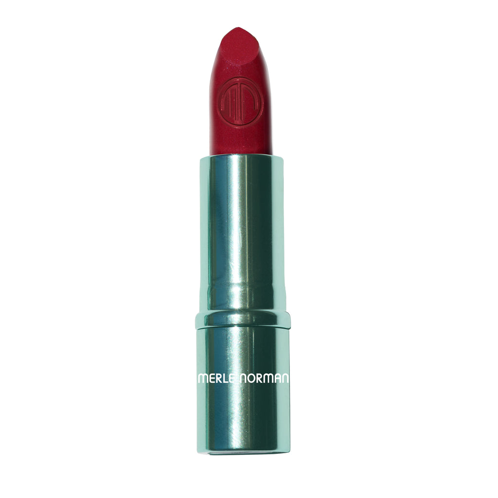 A single lipstick bullet in a metallic teal tube, shown upright on a plain white background. The lipstick bullet is a deep red, and the tube has the brand name 'MERLE NORMAN' printed in white near the bottom.