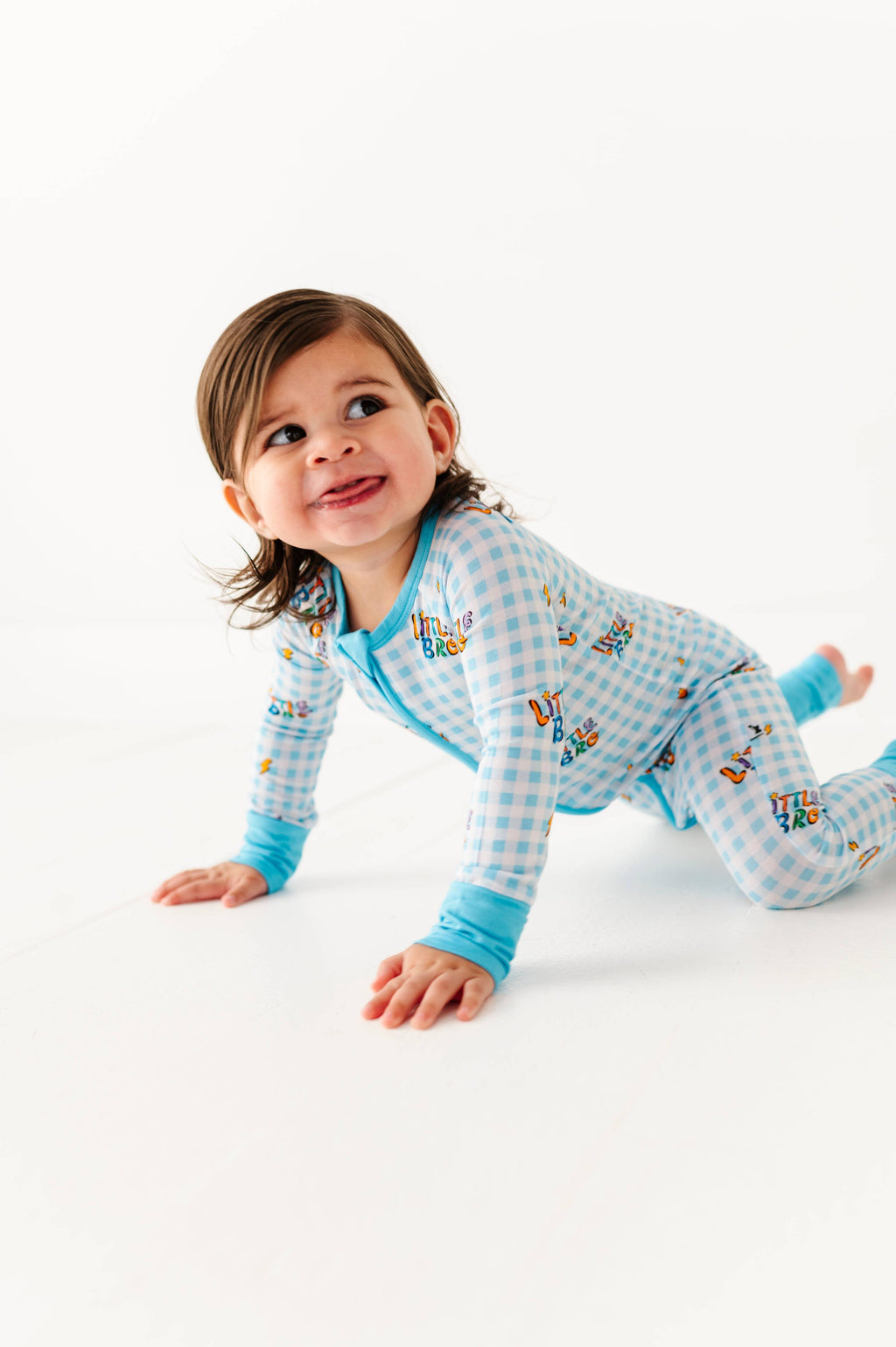 Child wearing a blue checkered outfit with cartoon characters on a white background