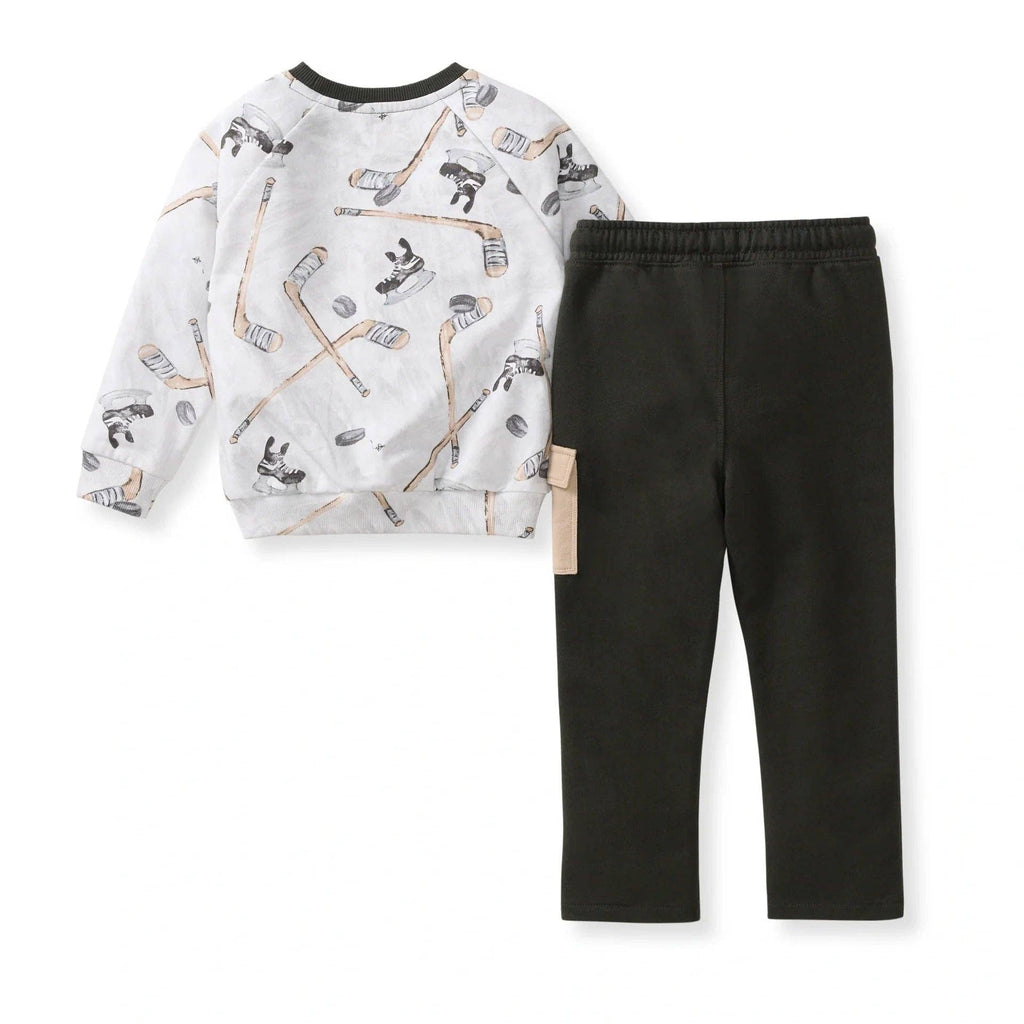 Burt's Bees Baby - Hockey Season Sweatshirt & Pants Set featuring a white sweatshirt with a hockey stick and puck pattern paired with solid black pants, perfect for cozy baby essentials from a curated children’s boutique.