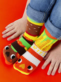 Child wearing Pals Socks - Burger & Fries - Fun Mismatched Non-Slip Socks for Kids featuring playful burger and fries designs, cozy and colorful for toddlers.