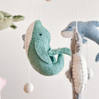 Close-up of handcrafted felt sea life animals including a whale, dolphin, and turtle hanging from strings in the Mobile - Felt Baby - Sea Life, perfect for a cozy baby nursery.