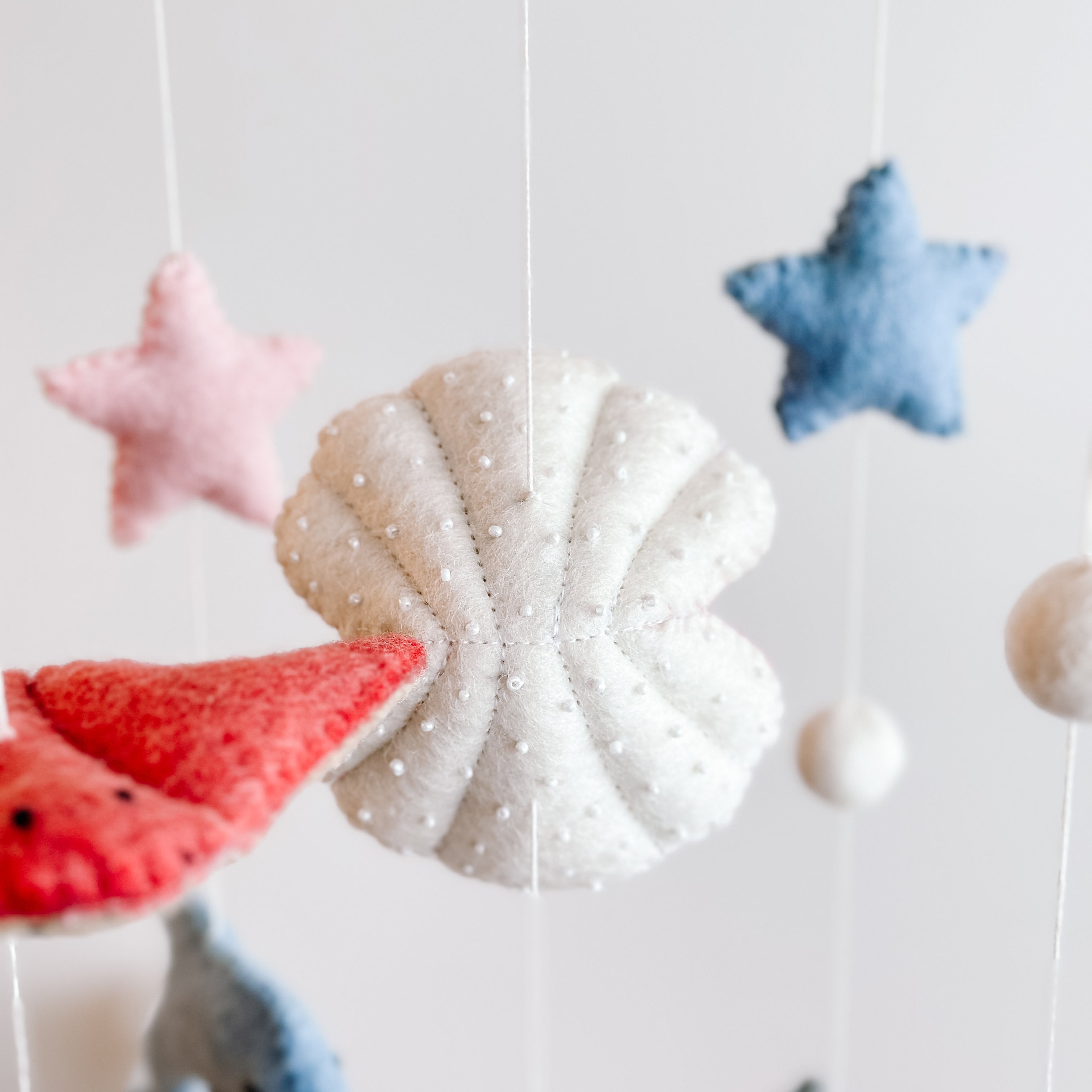 Mobile - Felt Baby - Sea Life with soft felt sea-themed shapes including a white textured shell, red starfish, and pastel stars, designed for soothing and stylish baby decor.