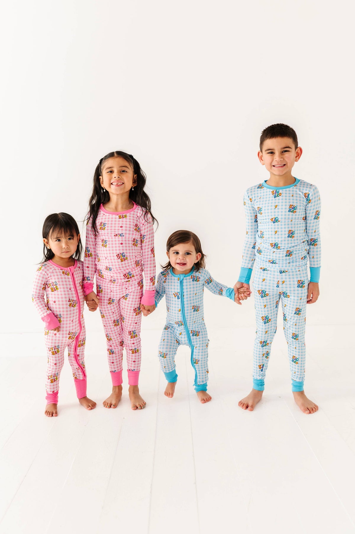 Four children wearing matching pajamas on a white background