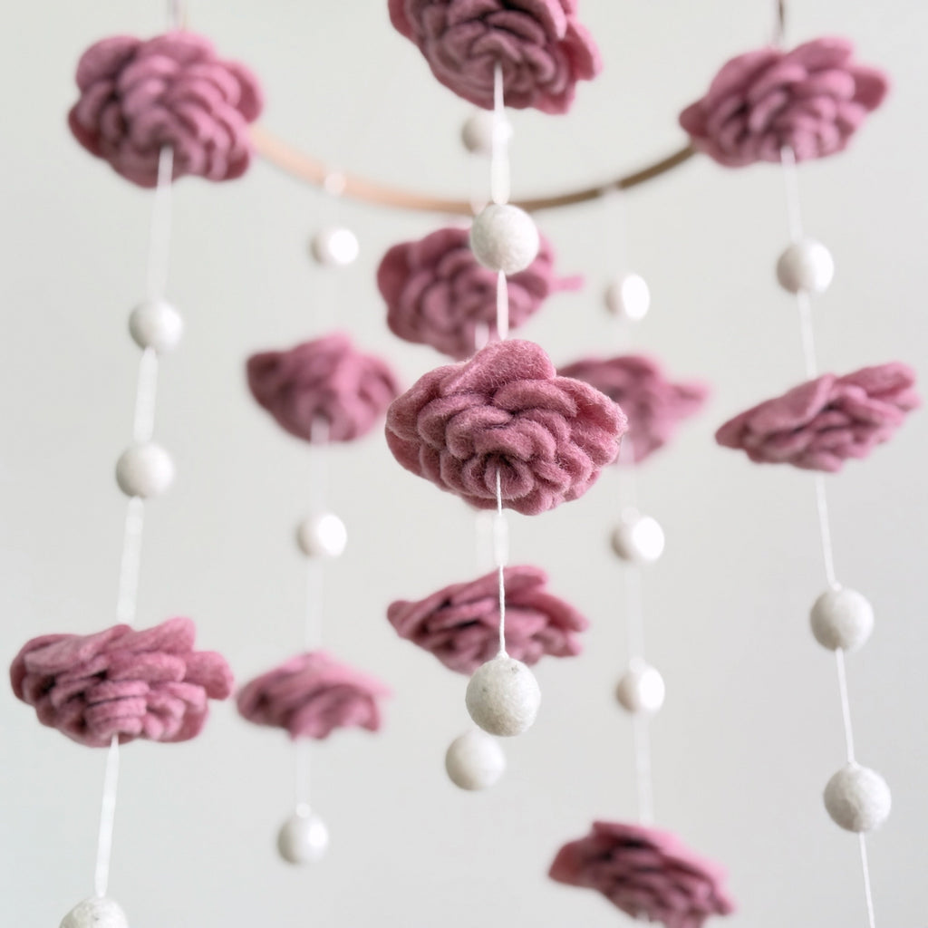 Mobile - Felt Baby - Blush Rose Flower features soft pink felt flowers and white felt balls hanging delicately, perfect for adding a cozy, stylish touch to a nursery.