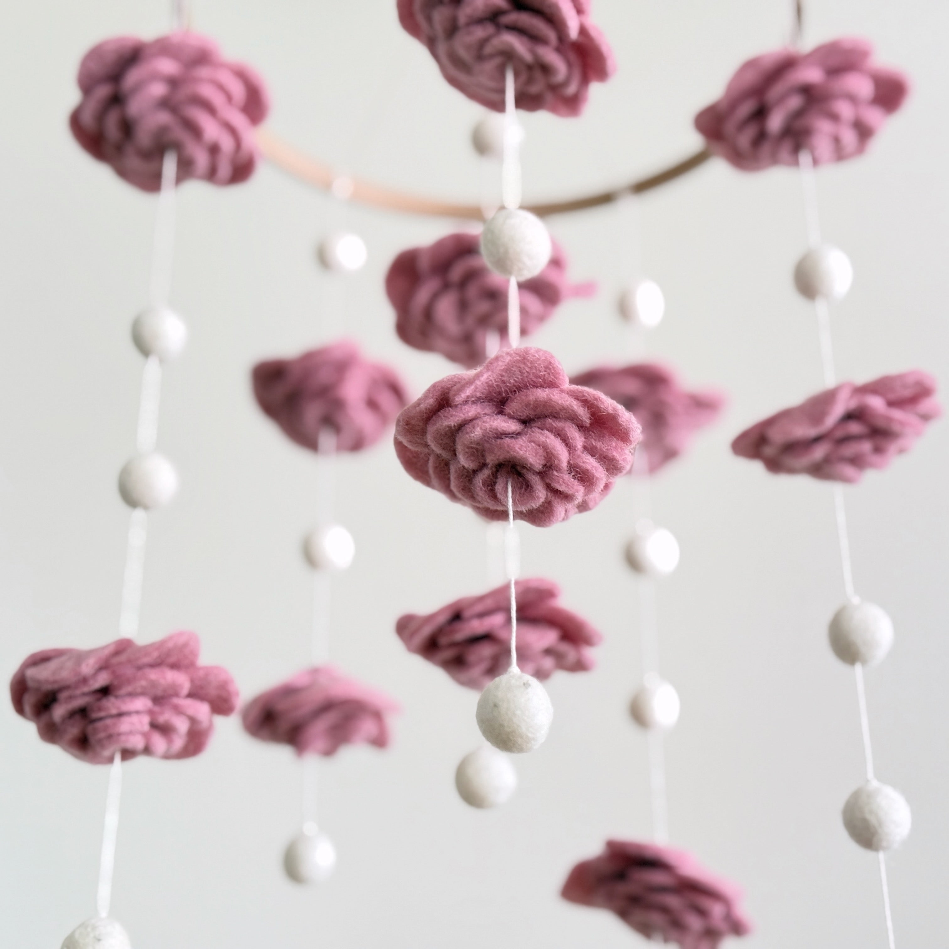 Mobile - Felt Baby - Blush Rose Flower features soft pink felt flowers and white felt balls hanging delicately, perfect for adding a cozy, stylish touch to a nursery.