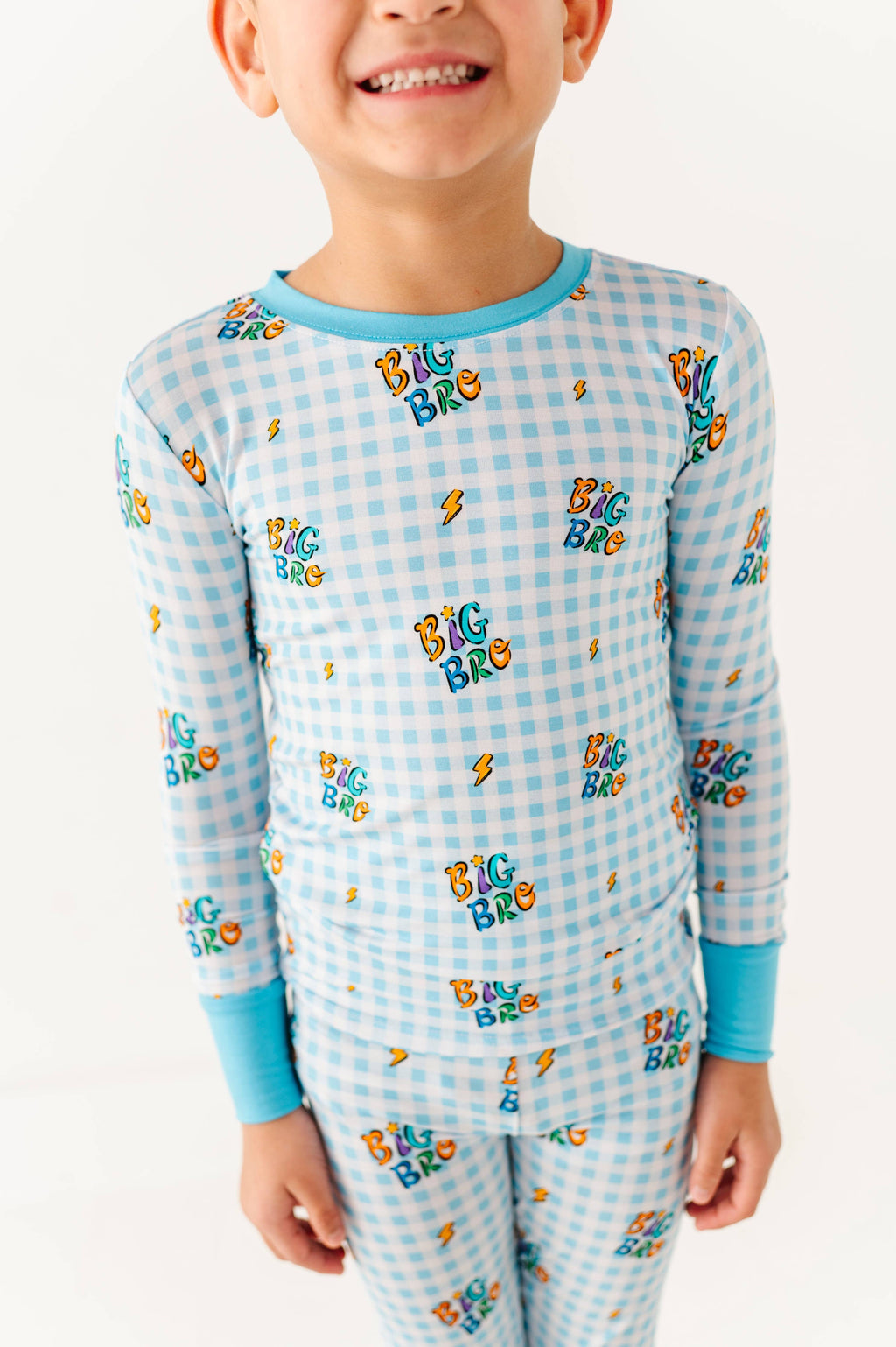 Child wearing a blue checkered pajama set with 'Big Bro' text on a white background