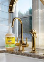 California Baby - Calendula™ Moisturizing Handwash bottle placed on a kitchen sink countertop next to elegant gold-toned faucet and sprayer in a cozy, sunlit space.
