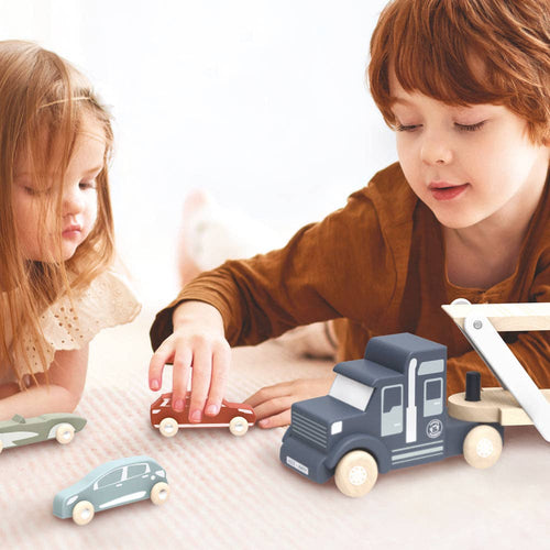 Two young children playing with wooden toy cars and a Speedy Monkey - Car Transporter on a soft, neutral-toned surface, capturing cozy and stylish kids playtime.